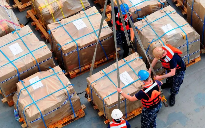 Crew securing strapped cargo on deck